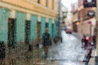 Riga 30 x 45 3/45 A rainy, atmospheric view of a cobblestone street through a textured glass window in Riga