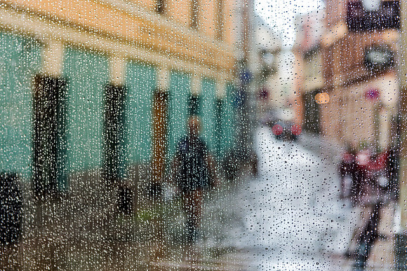 Riga 30 x 45 3/45 A rainy, atmospheric view of a cobblestone street through a textured glass window in Riga