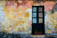 Colonia: Vibrant textures and weathered colors of a historic wall and blue door in Colonia Uruguay