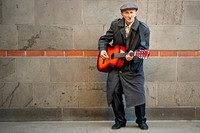 Swinging Jack in Cologne: A street musician plays guitar against a modern brick wall in Cologne, Germany