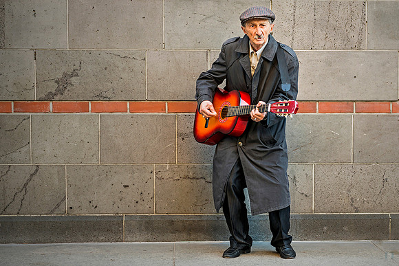 Swinging Jack in Cologne: A street musician plays guitar against a modern brick wall in Cologne, Germany