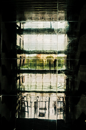 Wroclaw NMF: Rhythmic silhouettes of people captured through the layered glass of the Wroclaw Music Forum