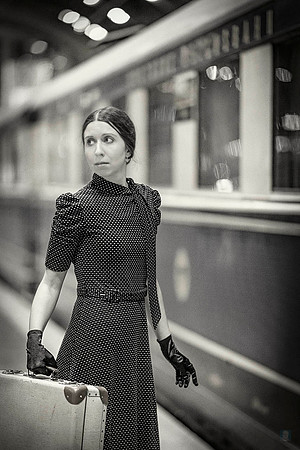 Pensive woman in retro attire gazes away, her silhouette reflecting a quiet, internal journey