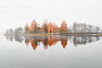 Trakai Castle Symmetrical reflection of the historic  Island Castle on a mirror-like, still and foggy lake