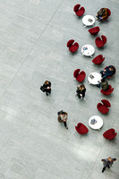 Vilnius K29K29  Minimalist aerial photography featuring a serpentine arrangement of red chairs on grey tiles with scattered figures